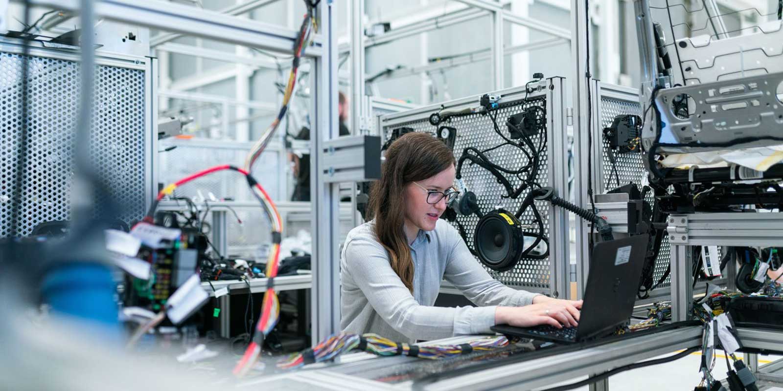 A woman working on a laptop in a technology lab.